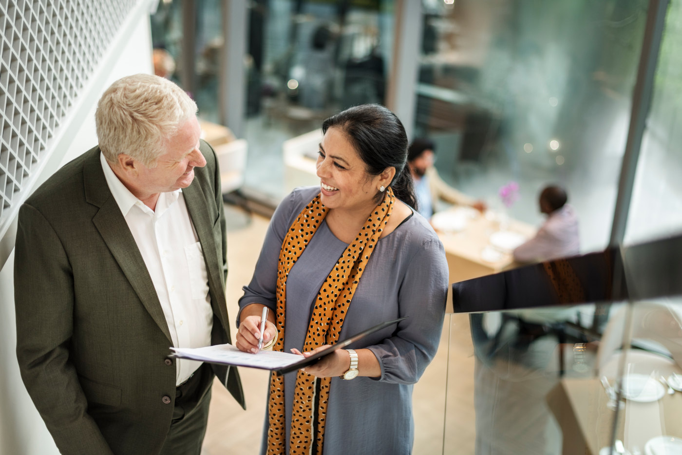 Financial advisor sitting with clients at a desk, discussing financial plans and strategy documents